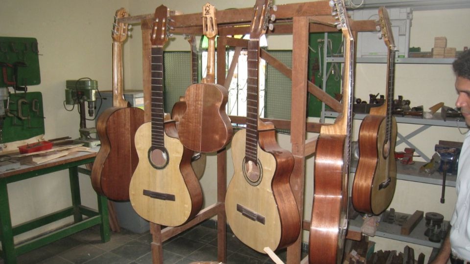 Oficina de luthieria com violões em construção em bancada de madeira